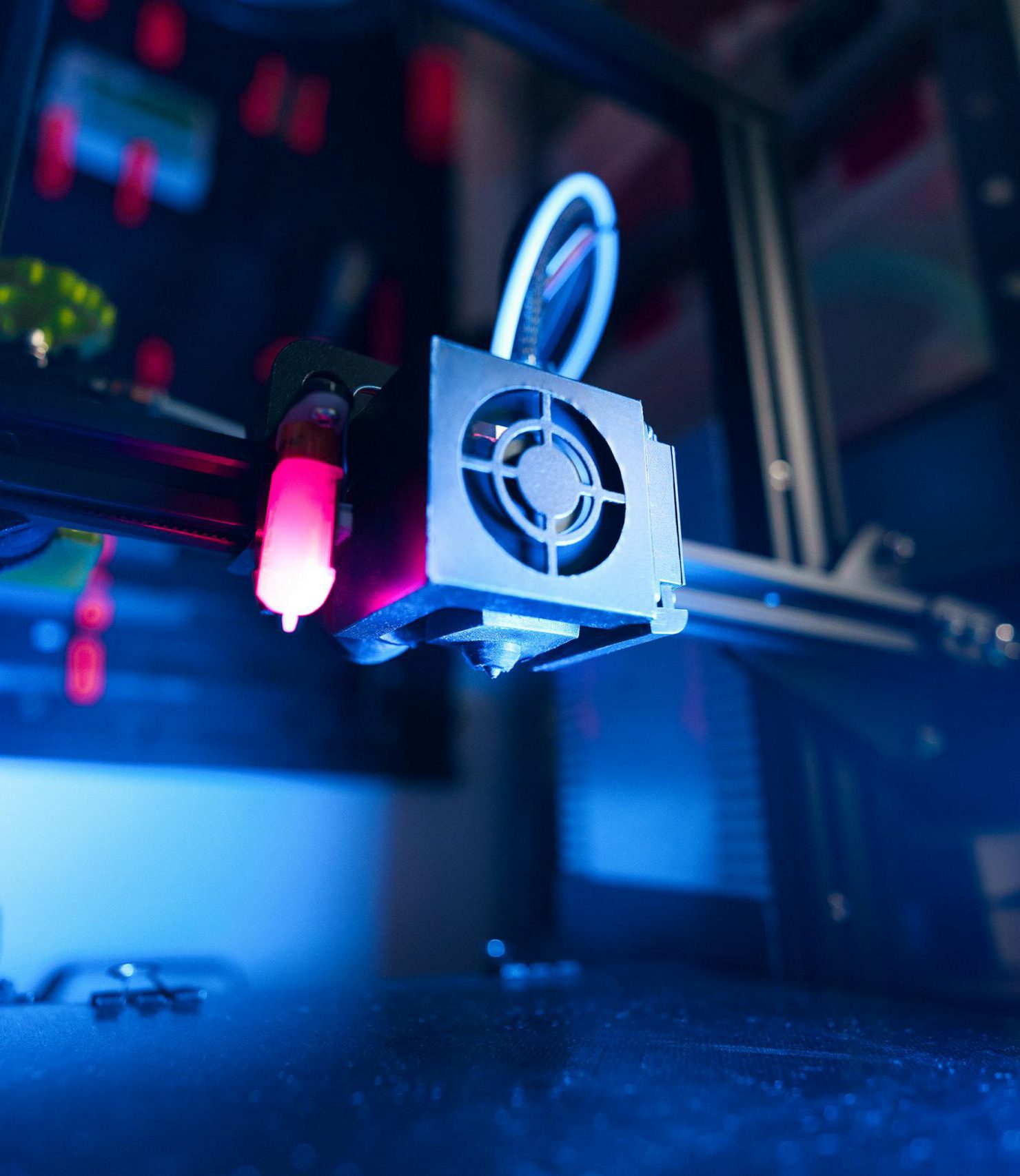 A close-up of an illuminated 3D printer in action, highlighting modern technology.